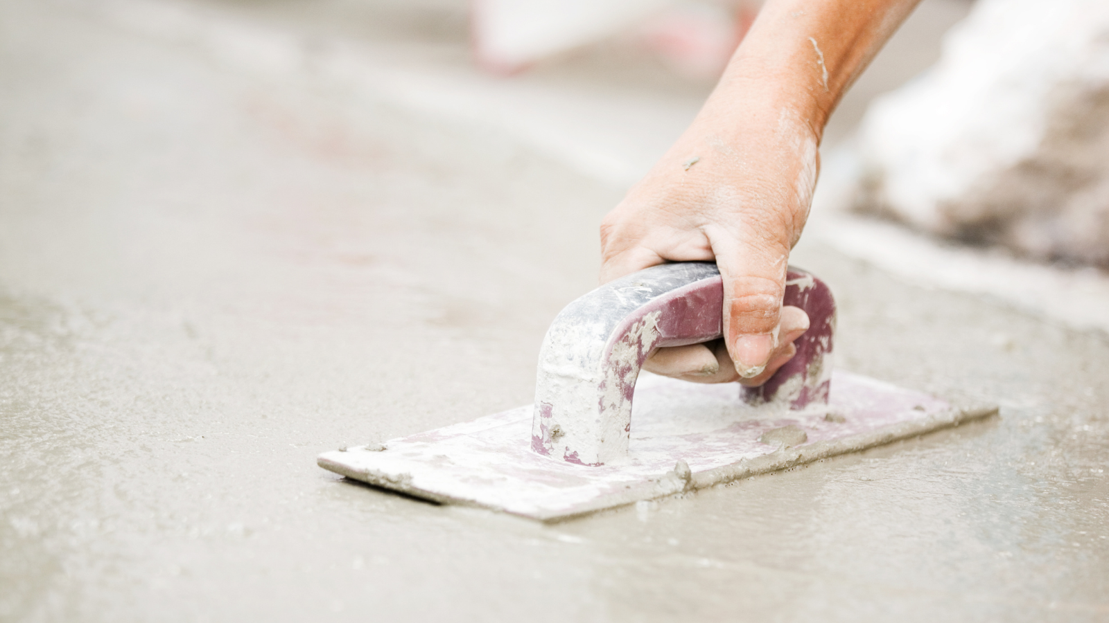 A worker smooths cement.