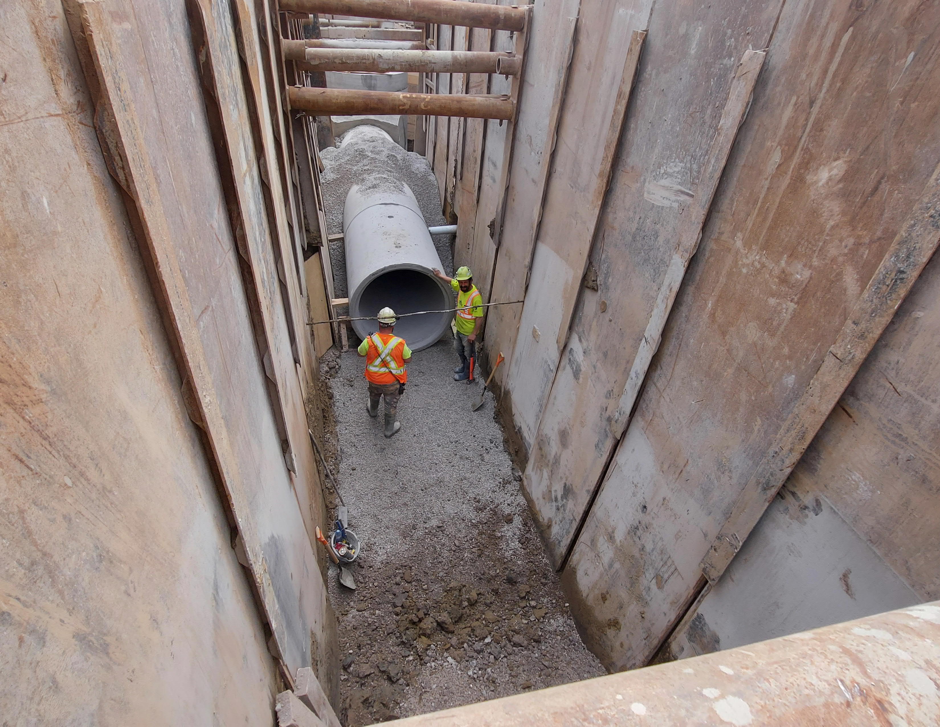 Construction workers install wastewater infrastructure underground on a street in Markham. 