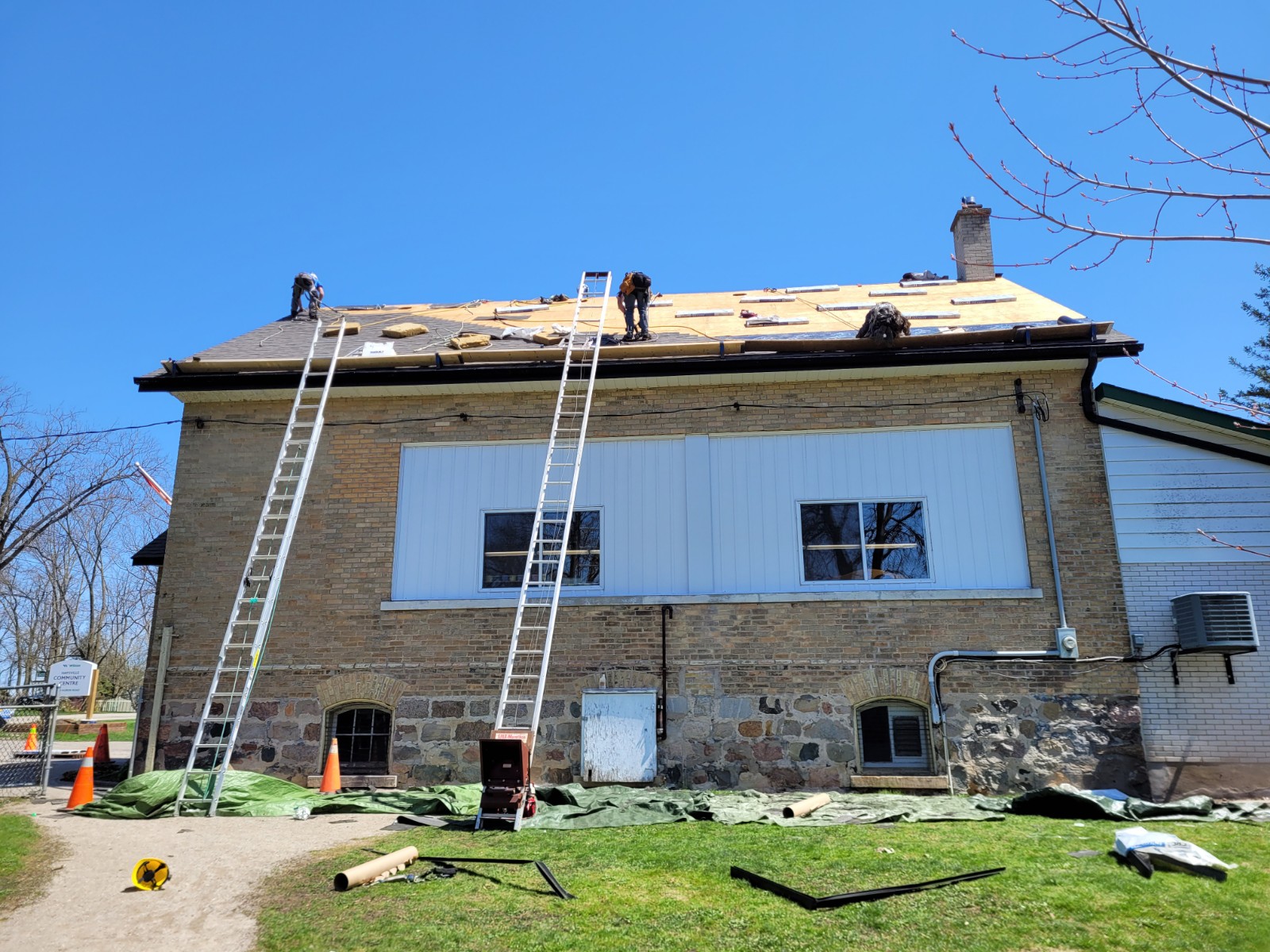 Roofers work to install new shingles on the Haysville Community Centre.