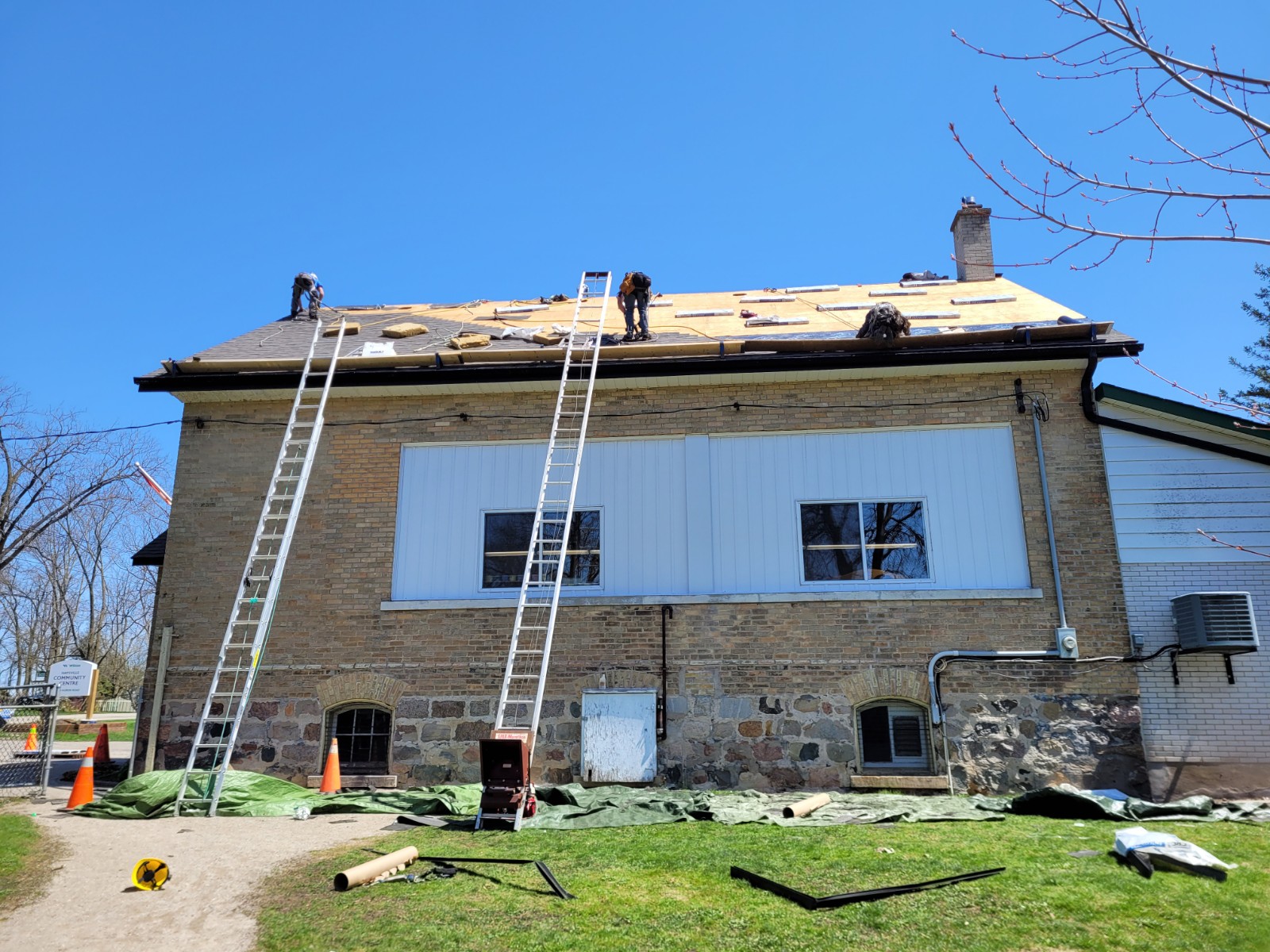 Roofers work to install new shingles on the Haysville Community Centre. 