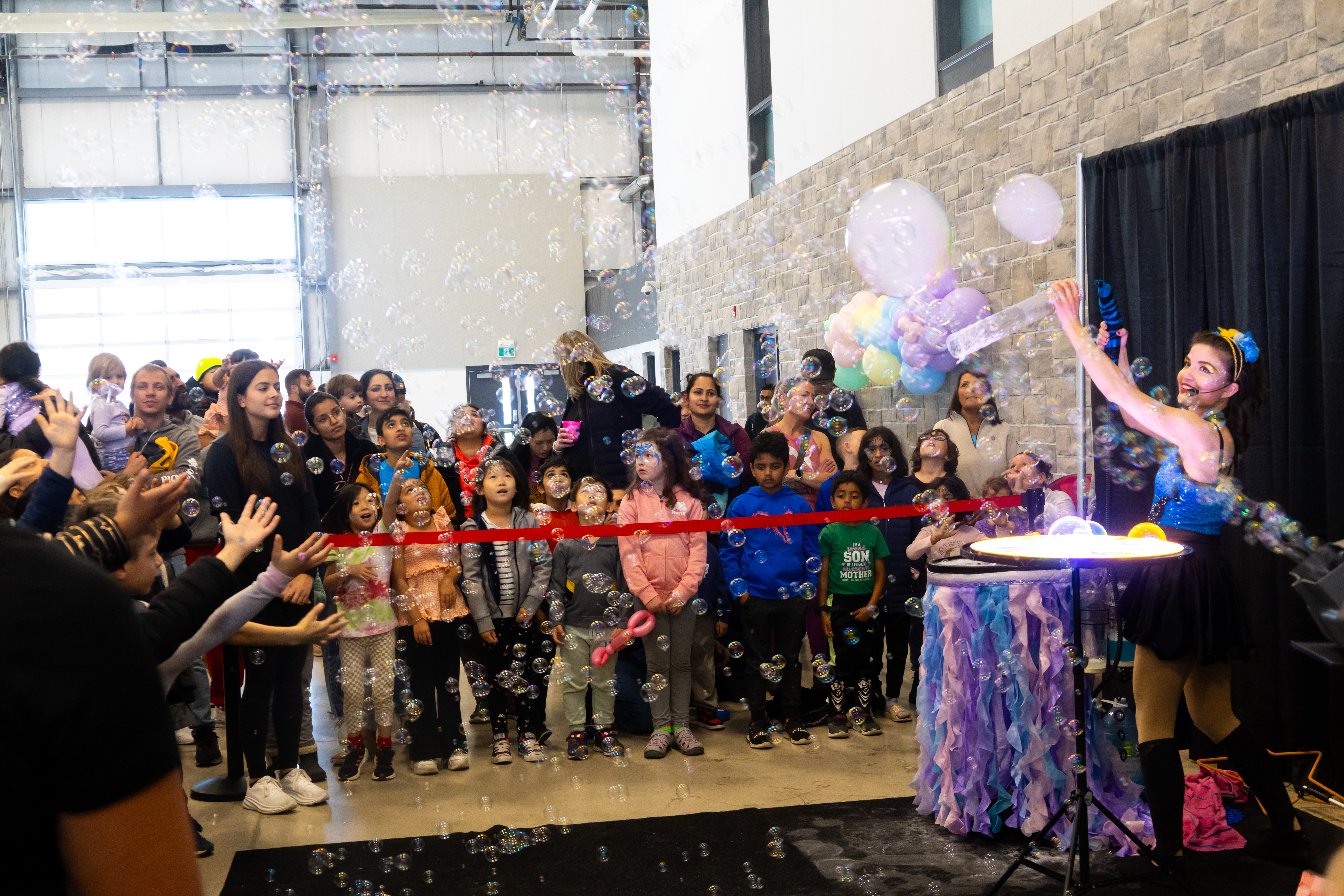 Kids and parents gathered around a bubble show