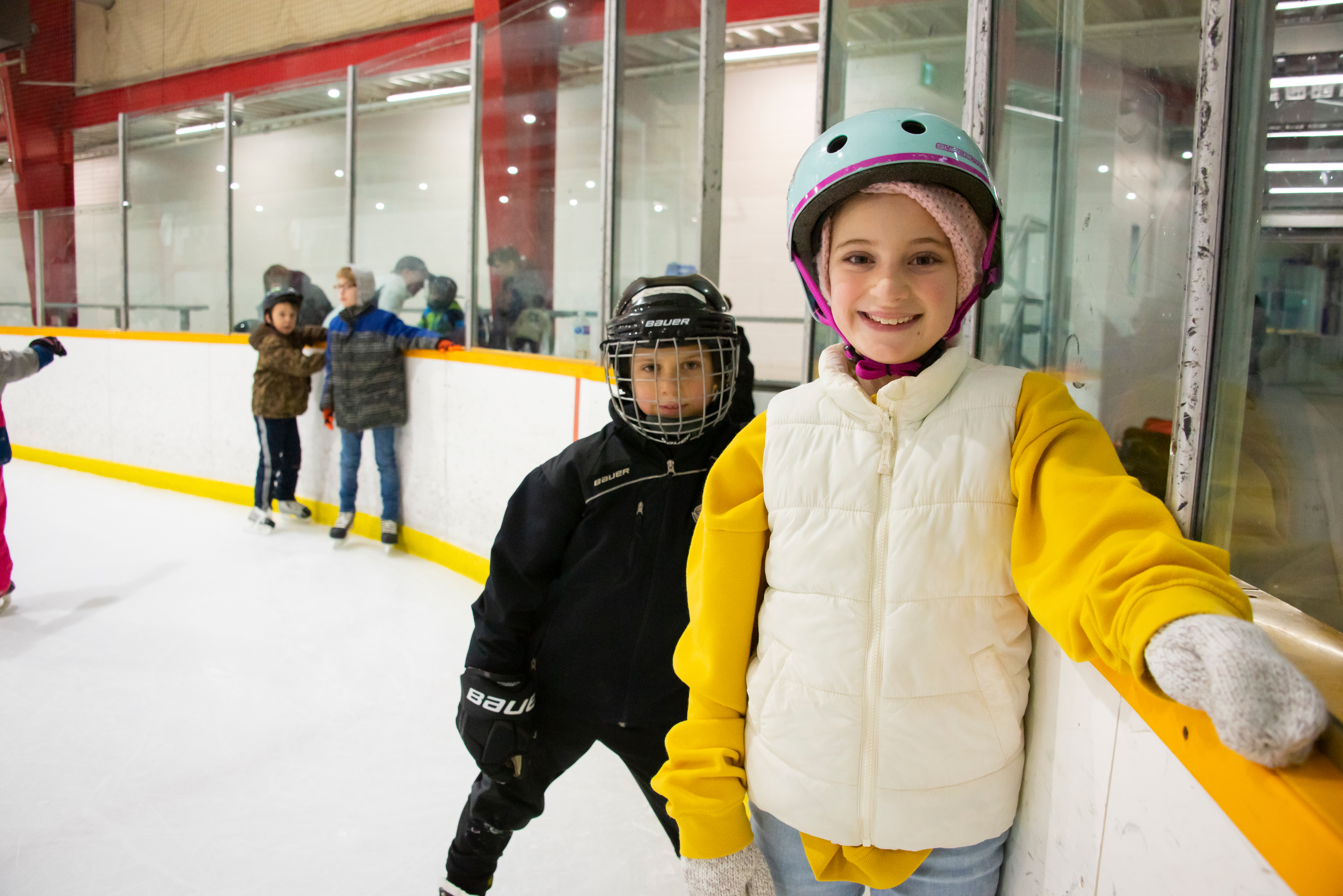 A kid smiling while ice skating
