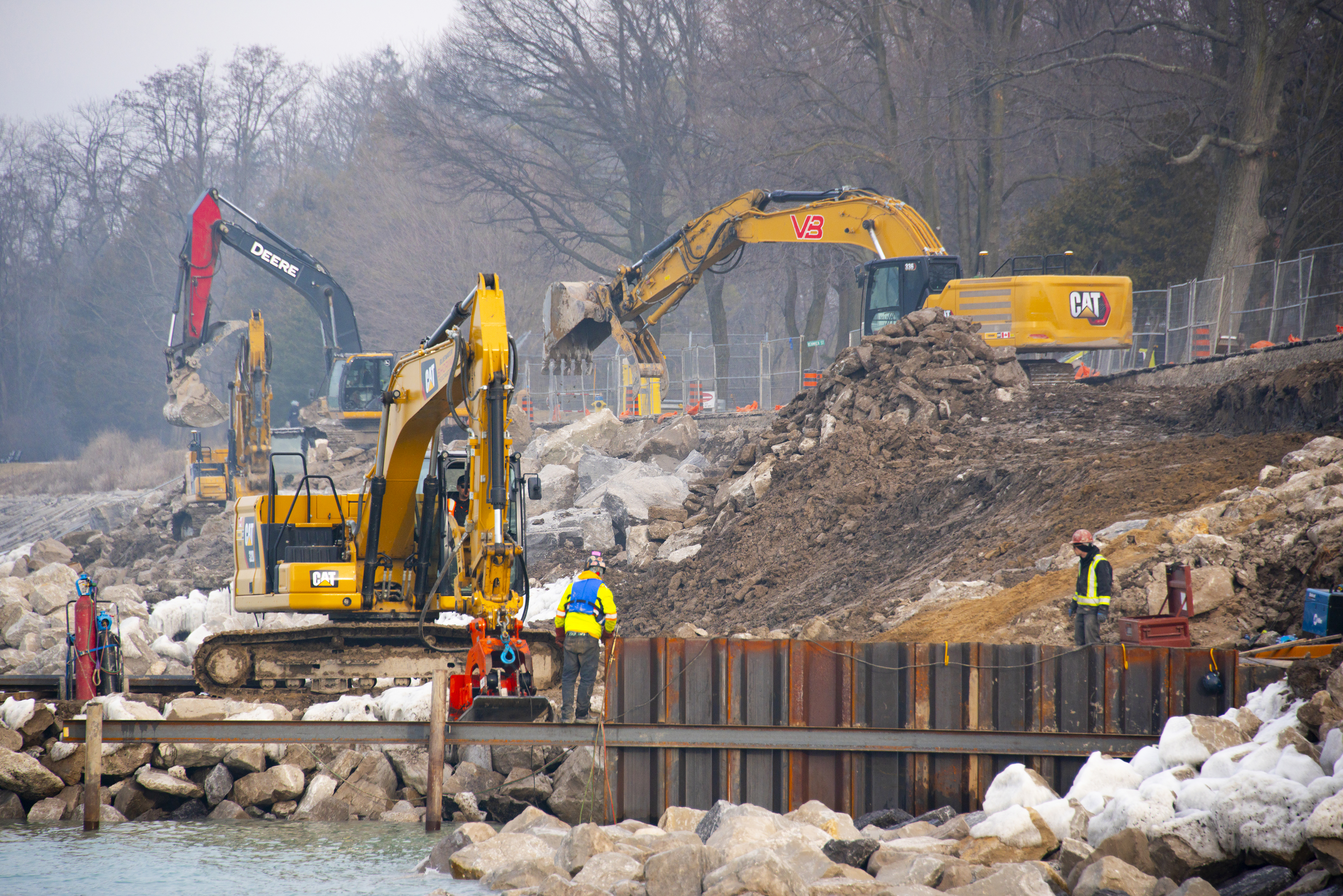 Construction workers installing protection measures on shoreline