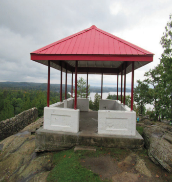 A gazebo overlooking trees and a lake