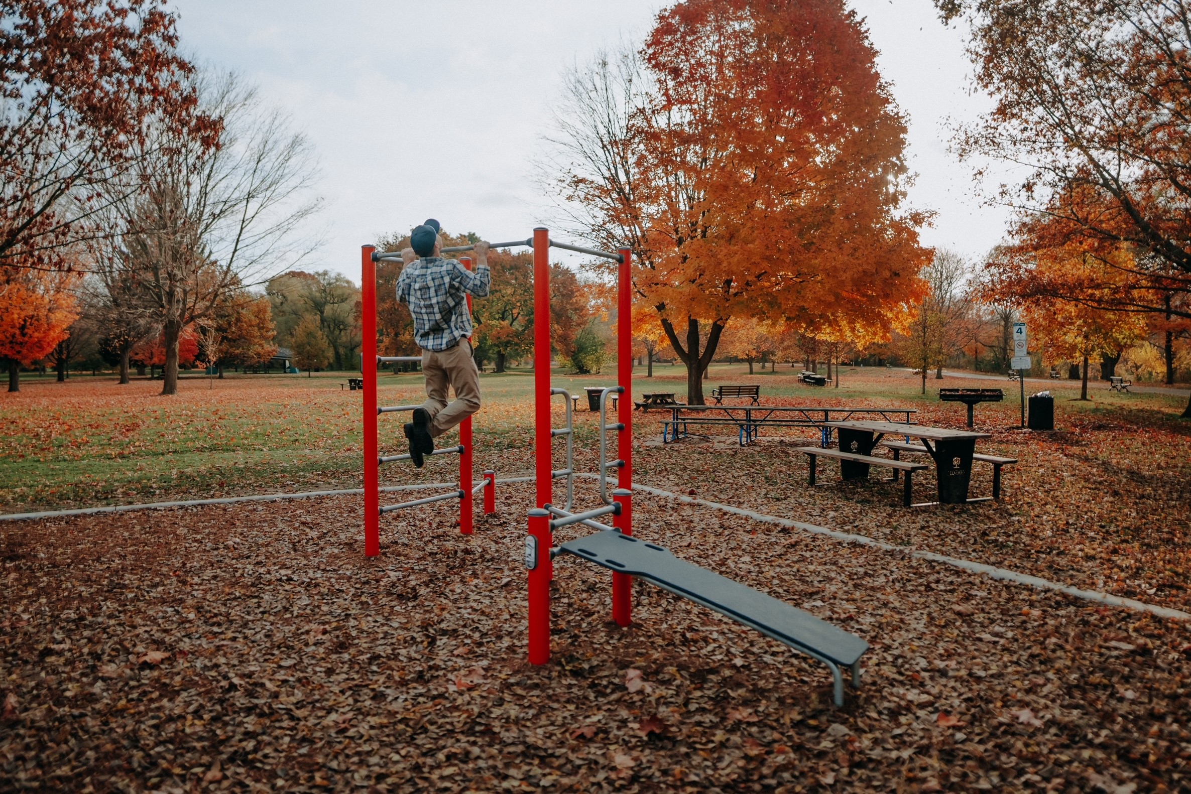Man doing pull ups on outdoor gym equipment