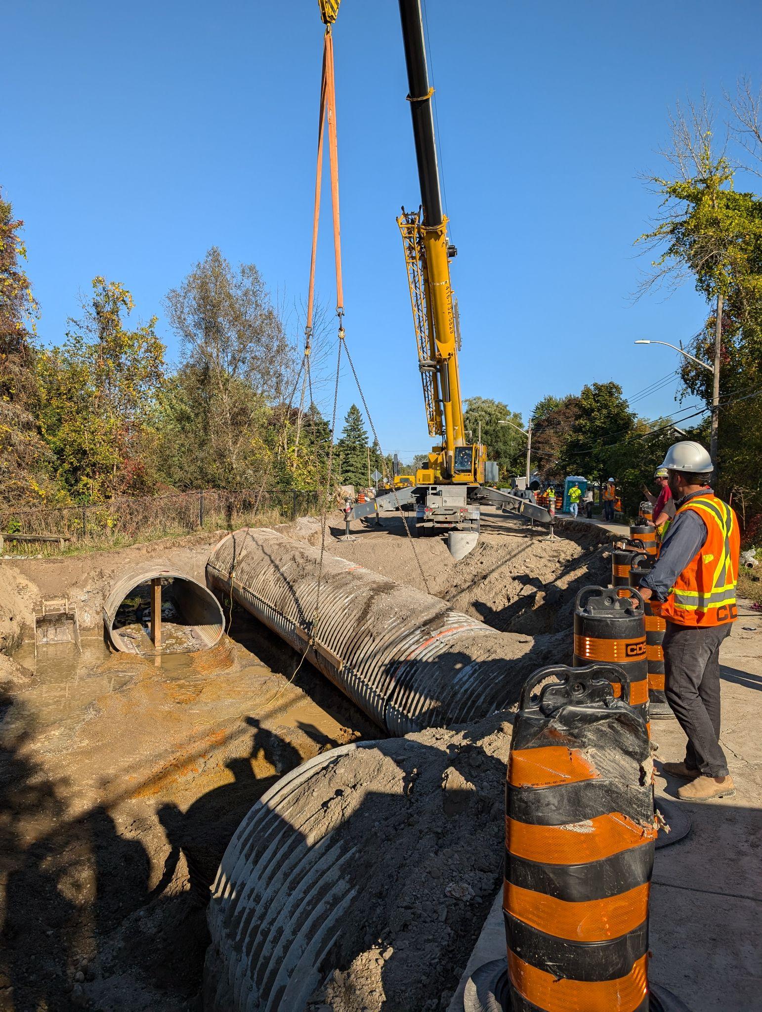 A large pipe being moved by a crane