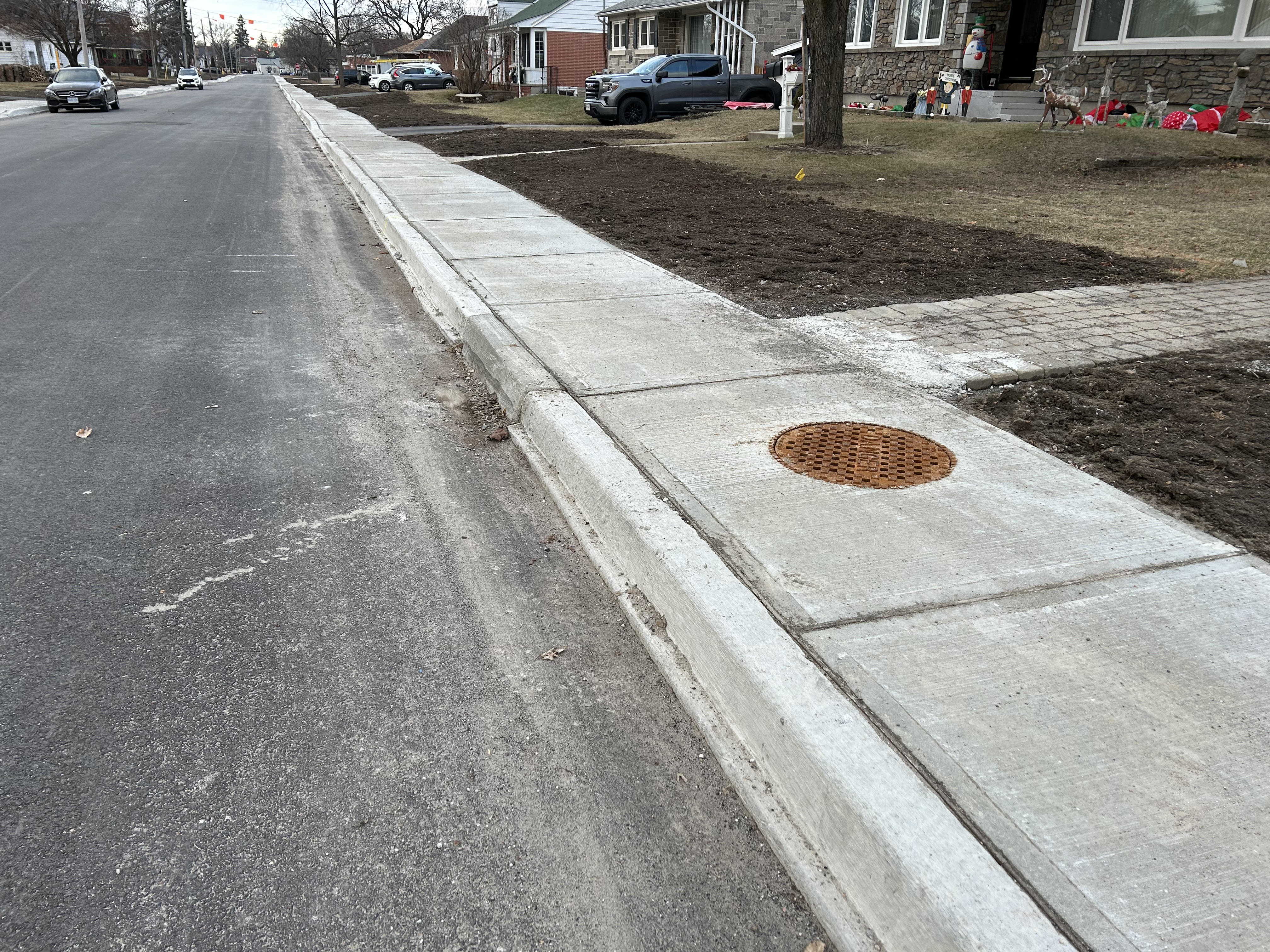 A sidewalk with a sewer grate