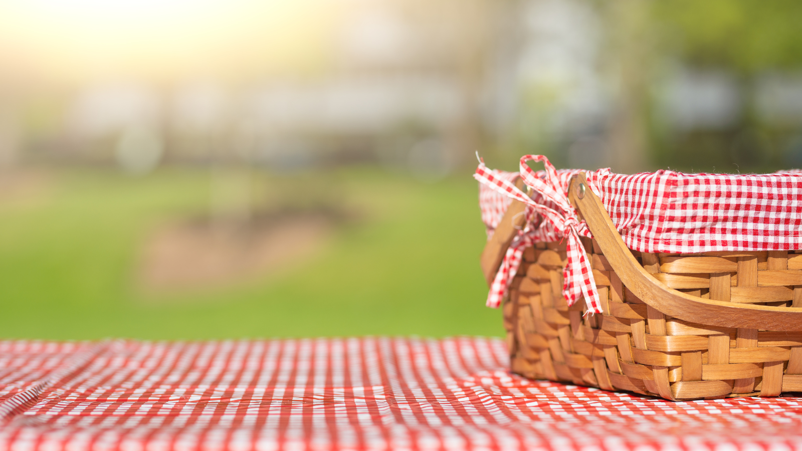 A stock image of a picnic basket in a park. 