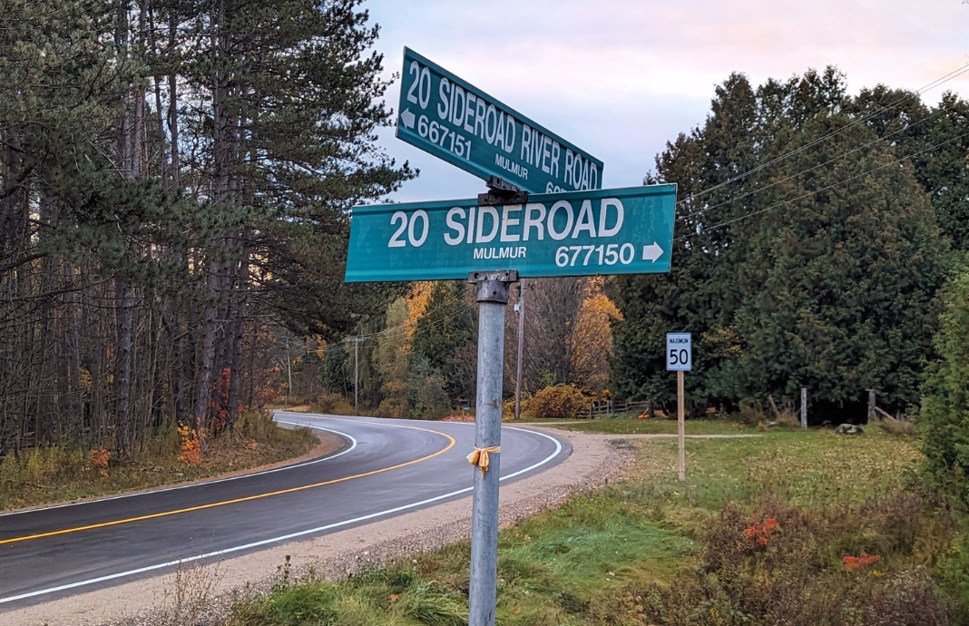 A photo of an intersection on a country road in Mulmur.