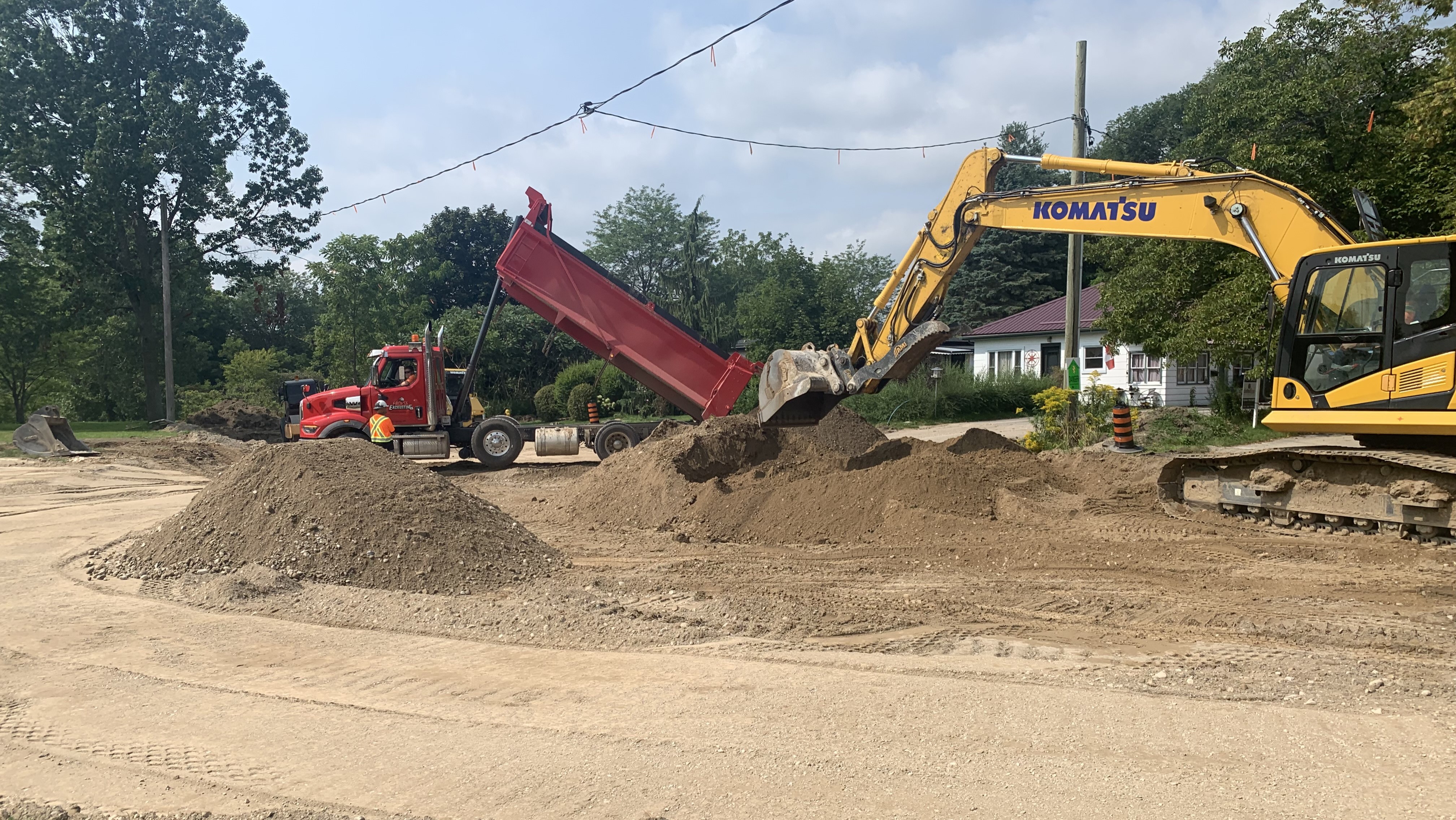 Construction equipment by a dirt road.