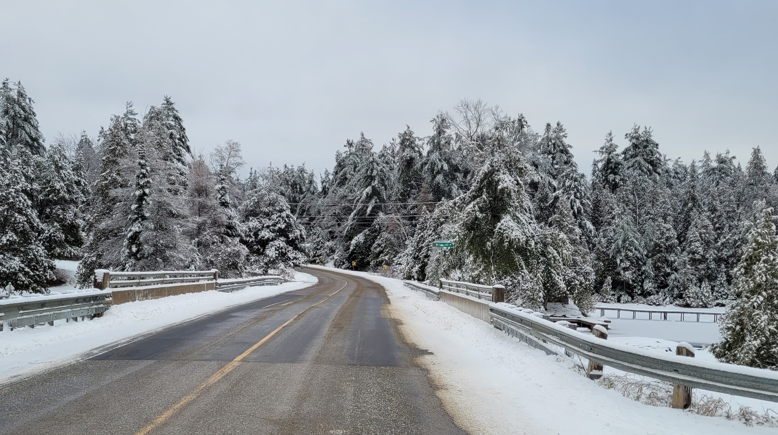 A snow covered bridge running over a river. 