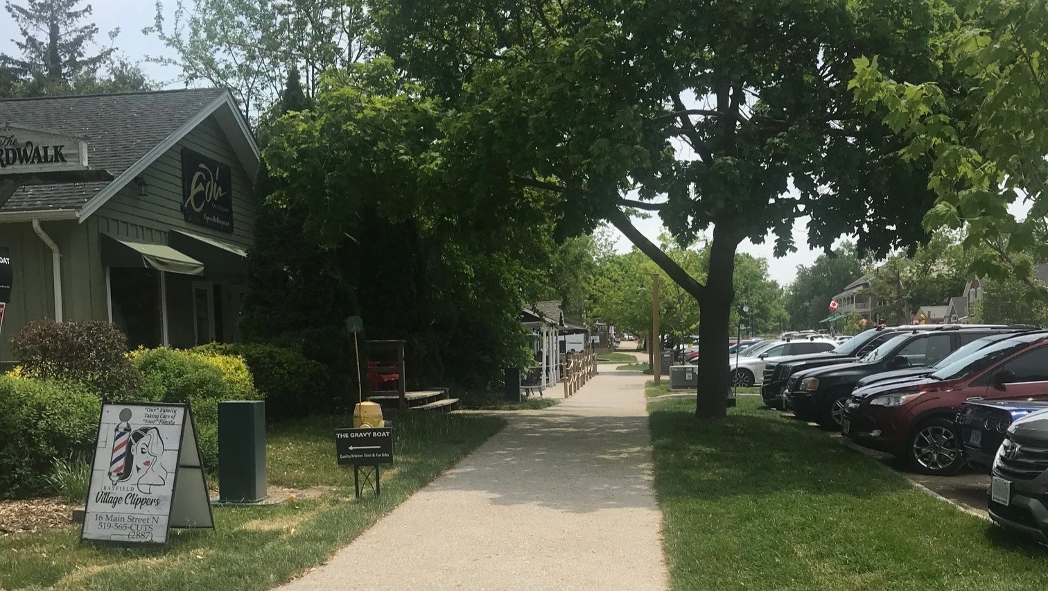 A sidewalk with multiple shops that would attract tourists