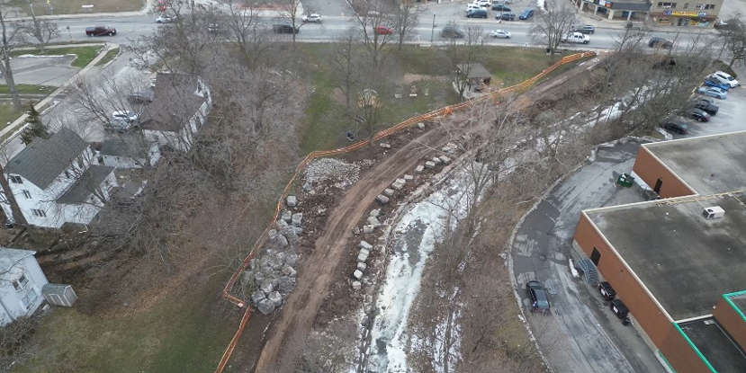 An overhead view of a park in winter with construction equipment