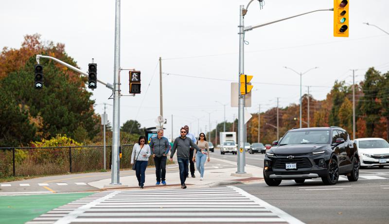 people walking across a crosswalk