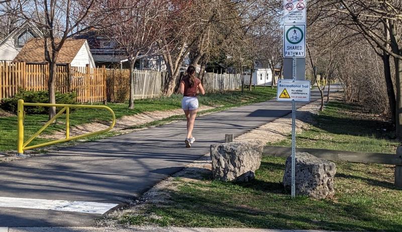 A woman running on a paved trail