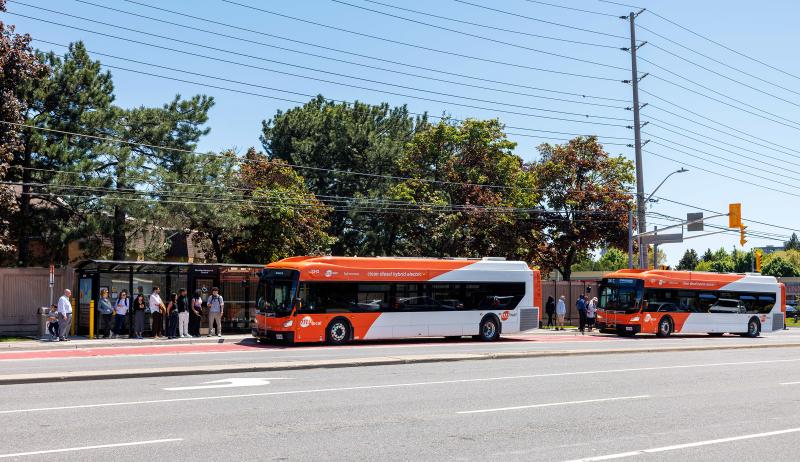 people loading buses at a bus station