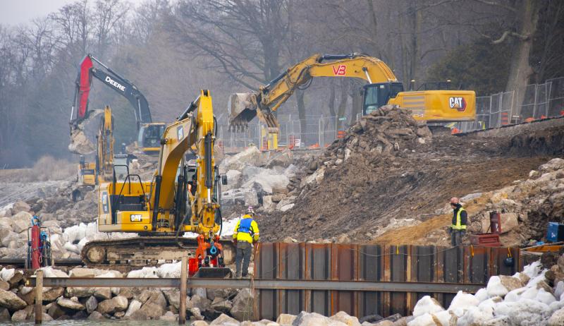 Construction workers installing protection measures on shoreline