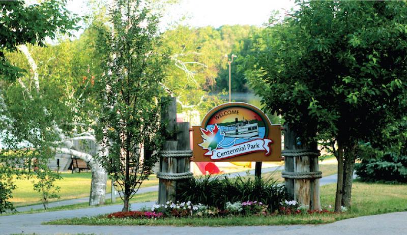 A welcome sign, or entryway sign, for the Municipality of Callander is shown in a park. 