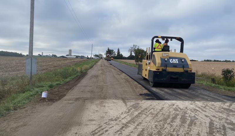 Road machinery paves a road in the Township of South-West Oxford.