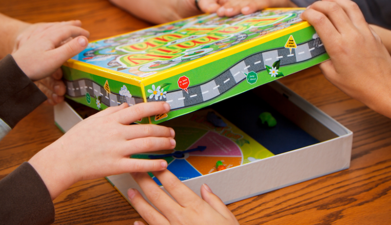 A stock image of children opening a board game. 
