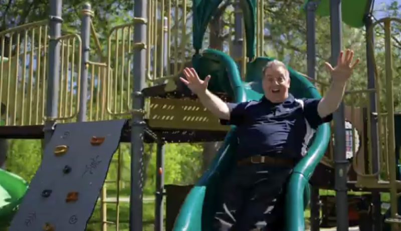 Mayor Cam Guthrie on a playground slide