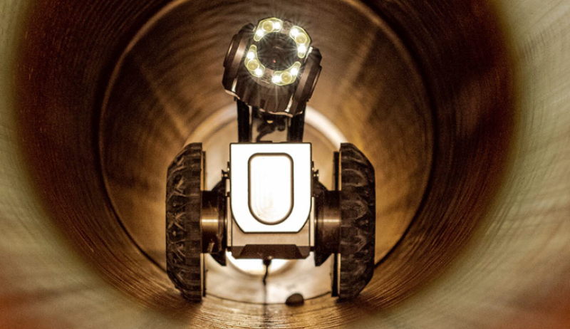 A special camera with bright lights and wheels inside a sewer
